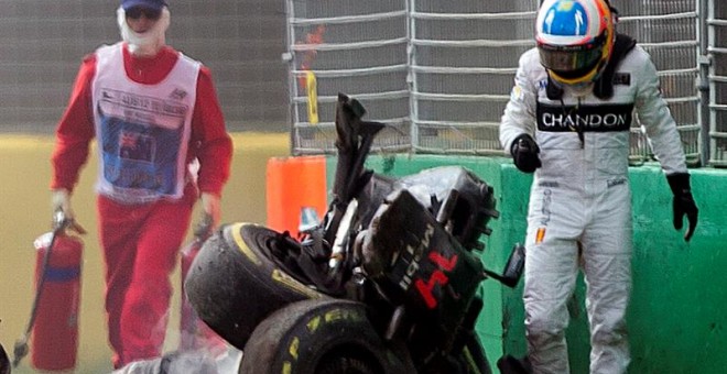 Alonso camina al lado de su monoplaza destrozado tras el accidente en Melbourne. /EFE
