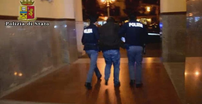 Imagen de un video de la Policía italiana de dos agentes con el argelino Djamal Eddin Ouali, arrestado por su supuesta relación con los terroristas yihadistas de Bruselas. EFE