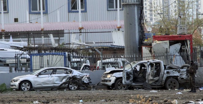 Un miembro de los cuerpos especiales de la Policía turca junto a los vehículos afectados por la explosión de un coche bomba en la ciudad kurda de Diyarbakir. REUTERS/Stringer