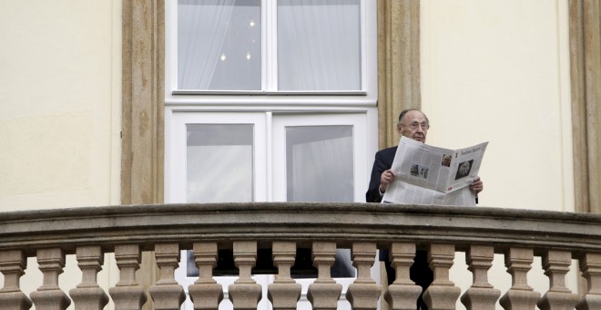 Former West German foreign minister Hans-Dietrich Genscher poses with newspapers on the balcony of the German embassy in Prague to mark the 25th anniversary of the East German exodus, in Prague in this file picture taken September 30, 2014. REUTERS/David