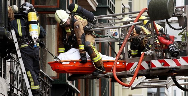 Rescate del cádaver del bombero fallecido mientras participaba en las labores de extinción del incendio declarado esta mañana en un edificio histórico situado en la calle Uría de Oviedo, al quedar atrapado en el momento en el que el inmueble se ha venido