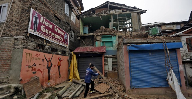 A man clears debris after his house partially collapsed following an earthquake, in Srinagar, India April 10, 2016. REUTERS/Danish Ismail