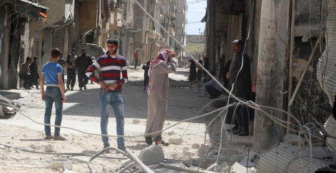 Los habitentes del barrio de al-Maysar, en Alepo, inspecciona los destrozos provocados por los bombardeos sobre las posiciones de los rebeldes sirios. REUTERS/Abdalrhman Ismail