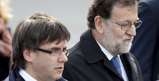 El presidente del Gobierno en funciones, Mariano Rajoy, con el president de la Generalitat, Carles Puigdemont, en el acto de homenaje a las víctimas del vuelo de Germanwings, en el aniversario del accidente. REUTERS/Albert Gea