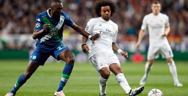 El defensa brasileño del Real Madrid Marcelo Vieira (d) centra el balón junto al francés Josuha Guilavogui, del Wolfsburgo. /EFE