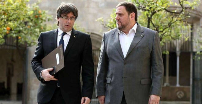 El presidente de la Generalitat, Carles Puigdemont y el vicepresidente Oriol Junqueras (derecha), a su llegada a la reunión semanal del ejecutivo catalán. /  TONI ALBIR (EFE)