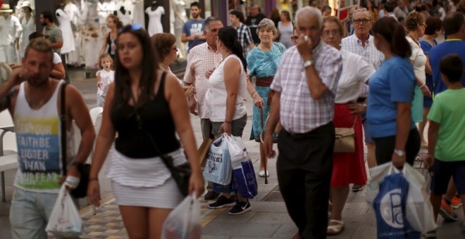 Personas con bolsas de la compra en la calle de La Bola, Ronda, España. REUTERS/Jon Nazca