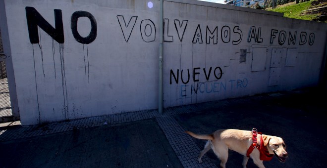 Un perro pasa junto a una pintada en una calle de Buenos Aires, que dice 'No volvamos al Fondo' (en referencia al FMI). REUTERS/Marcos Brindicci