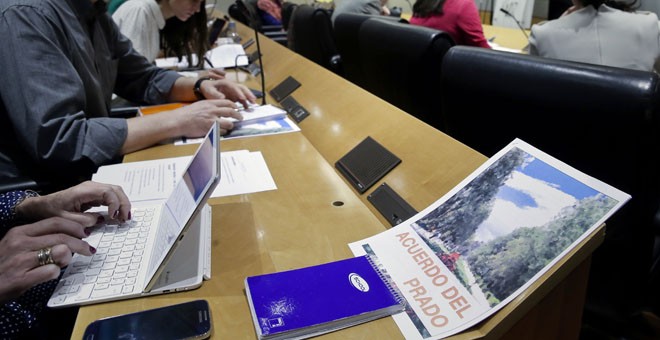 Un periodista tiene sobre la mesa de la sala de prensa del Congreso de los Diputados el documento de la propuesta de pacto de Compromís. EFE/Emilio Naranjo