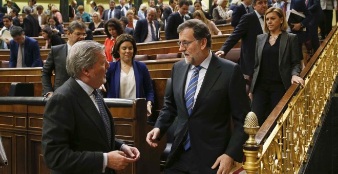 El presidente del Gobierno en funciones, Mariano Rajoy, conversa con el ministro de Educación en funciones, Íñigo Méndez de Vigo, al finalizar en el Congreso de los Diputados el último pleno de la XI Legislatura. EFE/Paco Campos