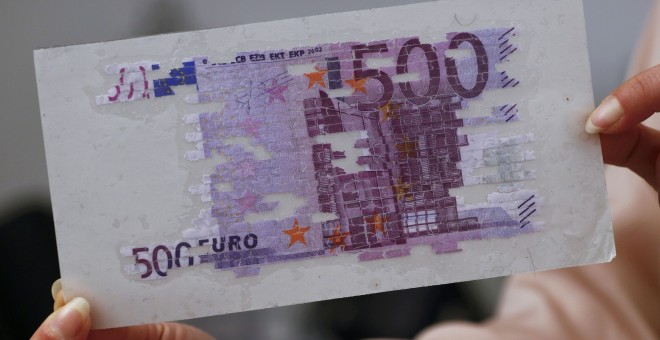 Un empleado del Banco Central de Austria (Nationalbank) muestra un billete de 500 euros restaurado en la sede del banco en Viena, Austria. REUTERS/Leonhard Foeger
