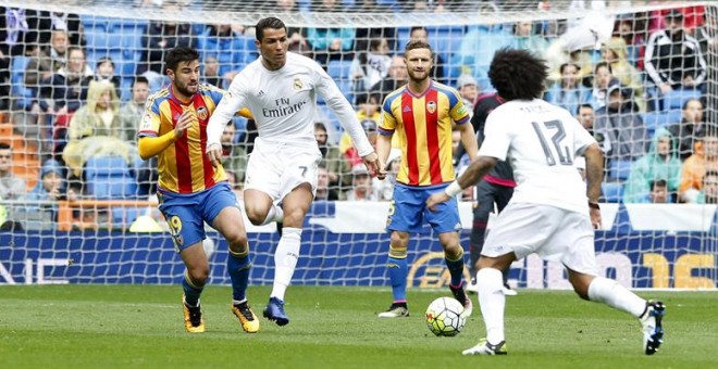 Cristiano conduce el balón ante dos jugadores del Valencia. /EFE