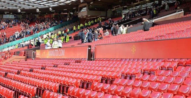 Los fans del Manchester United abandonan las gradas de Old Trafford después de los miembros de seguridad ordenaran evacuar el estado por la presencia de un paquete sospechoso. EFE