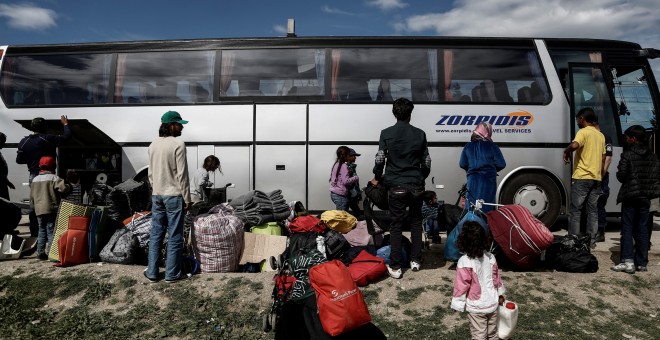 Refugiados sirios junto a un autobúis durante el desaolo policial del campo de Idomeni, en la frontera de Grecia con Macedonia. REUTERS/Yannis Kolesidis