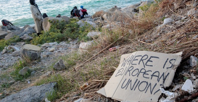 Inmigrantes y activistas sobre las rocas del malecón en el paso fronterizo San Ludovic, en la costa mediterránea entre Ventimiglia (Italia) y Menton (Francia). REUTERS / Eric Gaillard