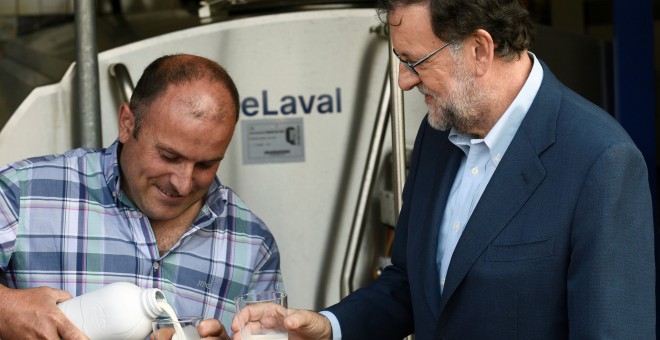 El presidente del Gobierno en funciones, Mariano Rajoy, junto al ganadero José Luis Fernández, durante la visita que realizó a la Ganadería Carbayeda, de la localidad asturiana de San Martín de Podes.REUTERS/Eloy Alonso