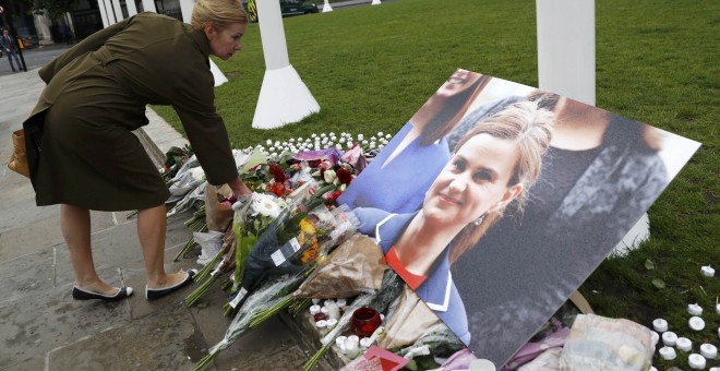 Una mujer deja flores en el lugar de homenaje a la diputada británica Jo Cox en Londres