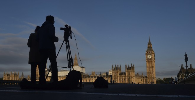 Un operador de cámara toma imágenes del amanecer ante las Casas del Parlamento en Londres (Reino Unido) hoy, 24 de junio de 2016. Los británicos se decantaron en referéndum por la 'libertad' frente al 'control' de la Unión Europea (UE), como esgrimieron l