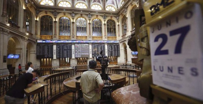 Un hombre mira las pantallas del IBEX-35 en Madrid. / EFE