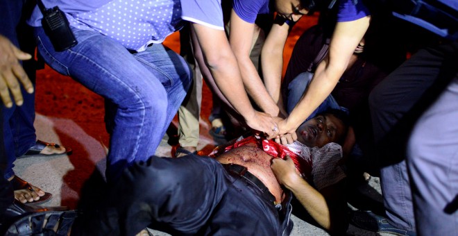 Una persona herida tras el asalto de los yihadistas a una cafetería en Dacca, la capital de Bangladesh.-REUTERS