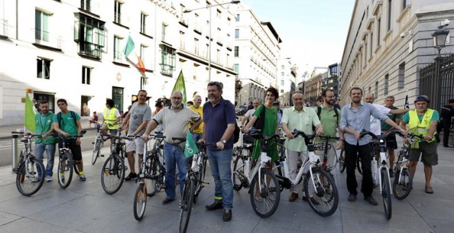 Integrantes de Equo, con Juantxo López de Uralde (c) a la cabeza, llegan en bicicleta al Congreso para asistir a la sesión constitutiva de las Cortes Generales de la XII legislatura. /EFE