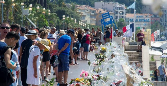 Multitud de personas se detienen ante las flores y velas depositadas en el paseo de los Ingleses en recuerdo a las víctimas cinco días después del atentado de Niza. - EFE