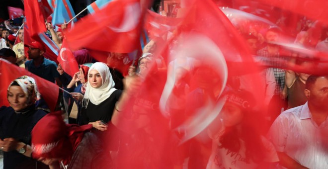 Seguidores del presidente turco, Recep Tayyip Erdogan, gritan consignas y sostienen banderas durante una manifestación. EFE