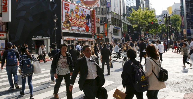 Varias personas cruzan una calle con comercios en el barrio Shinjuku de Tokio. REUTERS/Thomas Peter