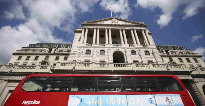 Un típo autobús londinense pasa por delante de la sede del Banco de Inglaterra, en la City. REUTERS/Neil Hall