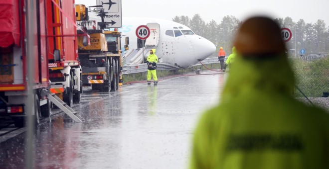 Varios operarios acondicionan una carretera después de que un avión de carga de la compañía DHL se saliera de la pista tras aterrizar la pasada madrugada en el aeropuerto italiano de Bergamo . EFE/Matteo Bazzi