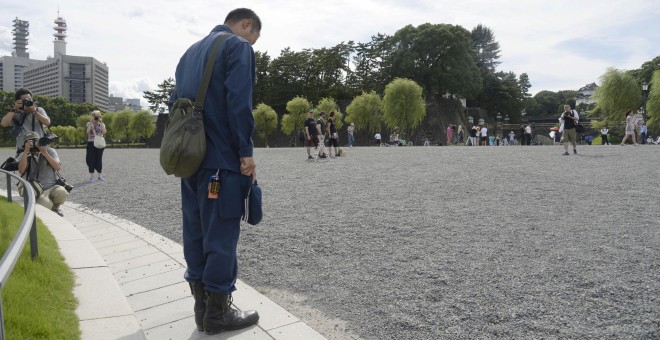 Un hombre inclina su cabeza cerca del Palacio Imperial mientras escucha el mensaje del emperador japonés Akihito en el que ha expresado su deseo de abdicar REUTERS/ Kyodo