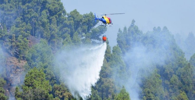 Un helicóptero trabaja en las labores de extinción del incendio en Villa de Mazo, en la isla de La Palma. Los equipos de emergencia concentran los esfuerzos en el frente que afecta a Montes de Luna y Tigalate, en Mazo. EFE/Miguel Calero