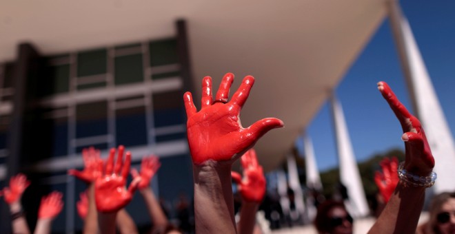 Manifestantes levantan sus manos teñidas de rojo en una manifestación en Braslia contra las violaciones. REUTERS