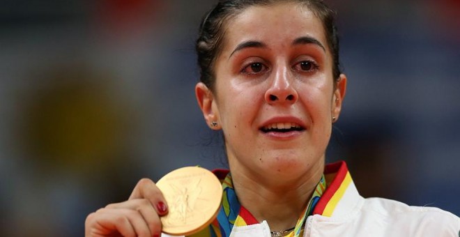 Carolina Marín sujeta la medalla de oro con los ojos enjugados en lágrimas. /EFE