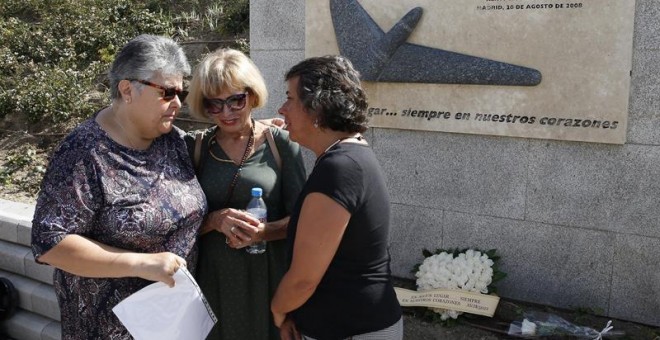 Familiares de los fallecidos lloran ante el lugar en el que se hace la ofrenda de flores en Madrid por el accidente de Spanair/EFE