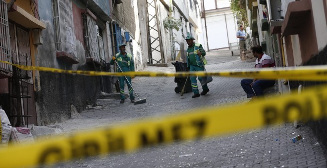 Empleados municipales limpian la calle de la localidad de Gaziantep, al sudeste de Turquía, donde se ubica el salón de bodas en el que se ha producido un atentado suicida que se ha saldado con una treintena de muertos y un centenar de heridos. EFE/EPA/SED
