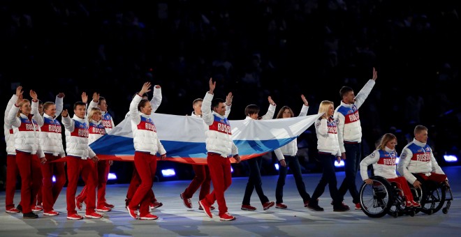 Participantes en la ceremonia de clausura de los Juegos Olímpicos de Invierno en Sochi (Rusia) portan la bandera rusa. REUTERS/Alexander Demianchuk