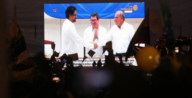 Fotografía de una pantalla gigante en Bogotá con la transmisión por televisión de la firma del acuerdo final que cierra las negociaciones de paz entre las FARC y el Gobierno. (EFE)