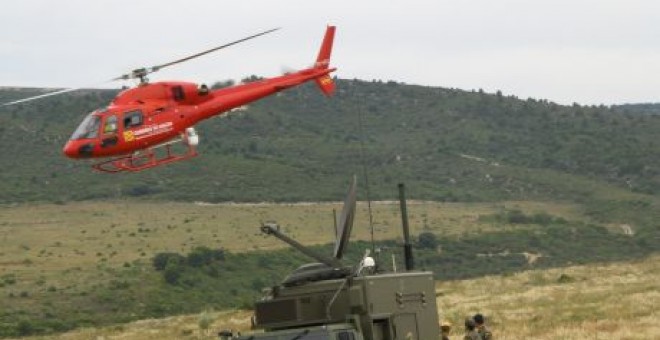Un grupo de soldados observa cómo un helicóptero del servicio de emergencias del Gobierno de Aragón sobrevuela una zona con riesgo de incendio./Aragonhoy.net