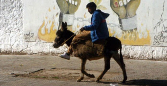 Un hombre monta un burro en las calles de Marruecos.