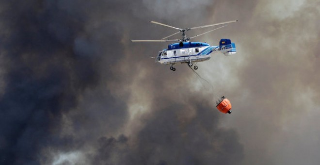 Un helicóptero sobrevuela el incendio en Benitatxell, Alicante/REUTERS