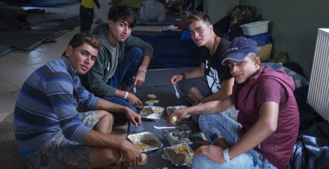 Un grupo de refugiados comiendo el menú preparado por los voluntarios.-PROYECTO ZAPOREAK