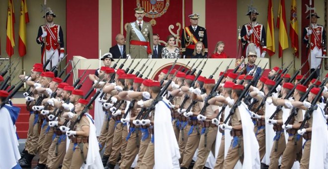 Los Reyes junto a sus hijas la Princesa de Asturias y la infanta Sofía, observan el paso de los Regulares de Ceuta, durante el desfile militar que han presidido dentro del acto central del Día de la Fiesta Nacional en el que se rinde homenaje a la Bandera