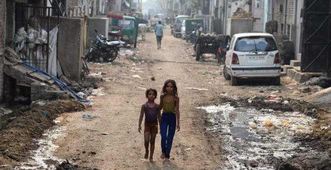 Dos niños pasean por una calle de Nueva Delhi. - AFP