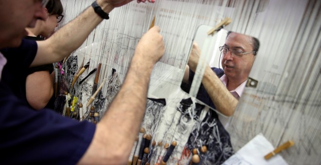 José Antonio Carbajal, empleado de la Real Fábrica de Tapices, teje en un telar de siglos de antigüedad. REUTERS / Susana Vera