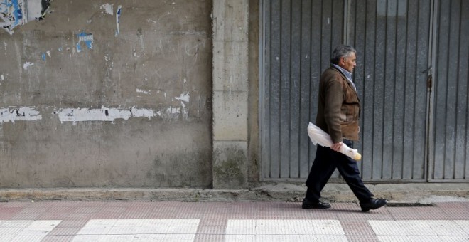 Un pensionistas camina por una calle del pueblo burgalés de  Briviesca. AFP / César Manso