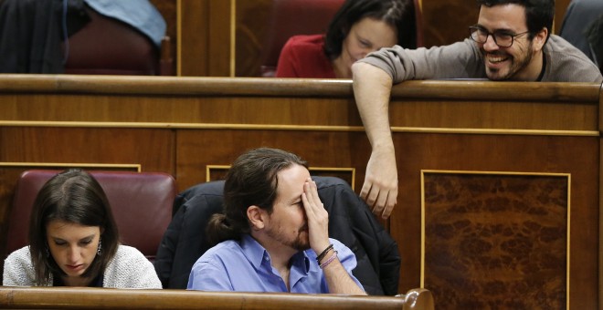 El coordinador federal de Izquierda Unida, Alberto Garzón, conversa con el líder de Podemos, Pablo Iglesias, durante el pleno del Congreso. EFE/Mariscal