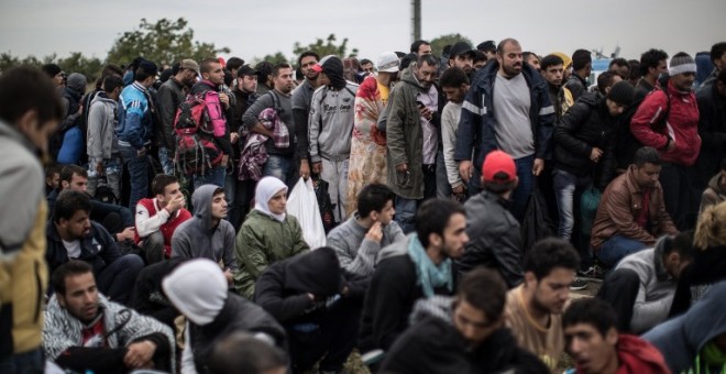 Decenas de personas esperan a poder pasar al centro de refugiados de Opatovac, en Croacia. - AFP