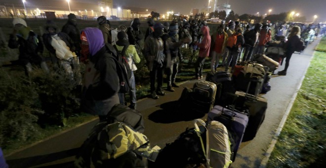 Refugiados del campo de refugiados de Calais esperando el traslado a los centros provisionales que Francia ha habilitado. REUTERS/Philippe Wojazer