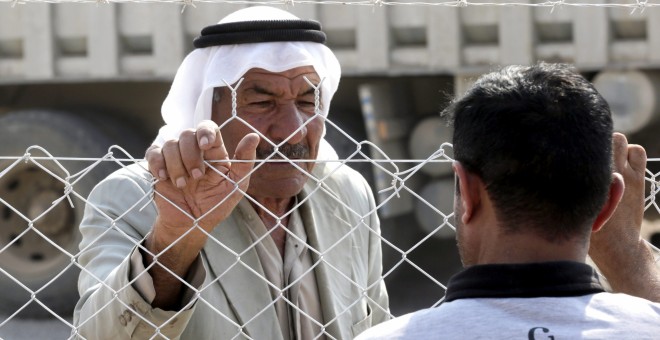 Un hombre iraquí de Mosul desplazado conversa con su familiar desde el centro de personas desplazadas en Khazir, a 37 kilómetros de Mosul, Irak.  / EFE